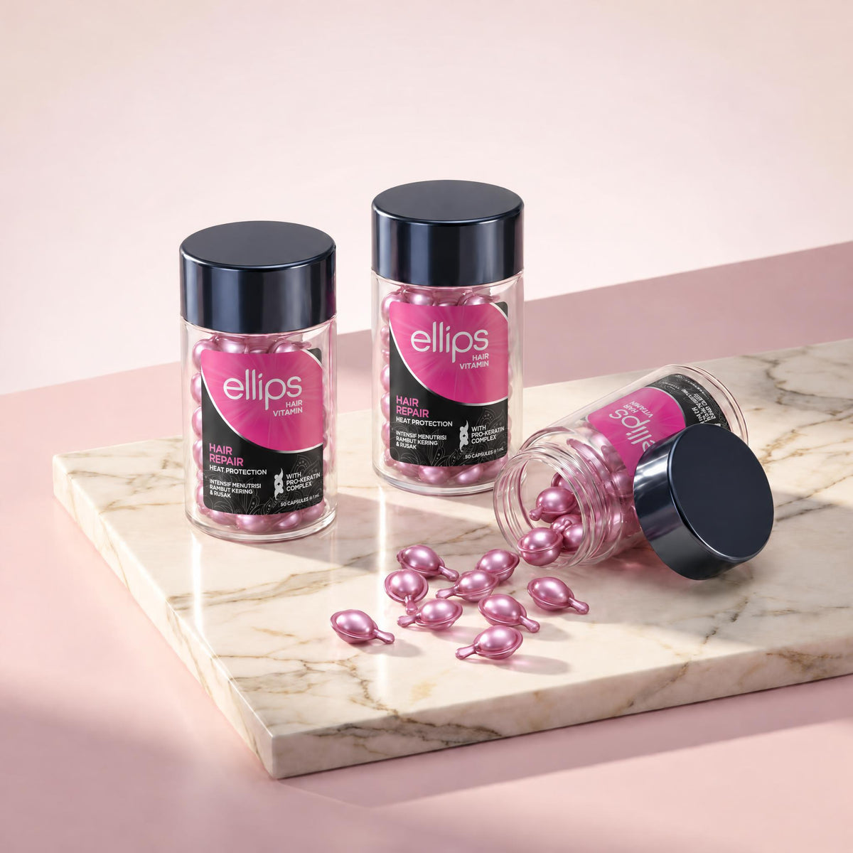 Ellips Hair Repair jars on marble, pearly pink capsules spilling from an open jar