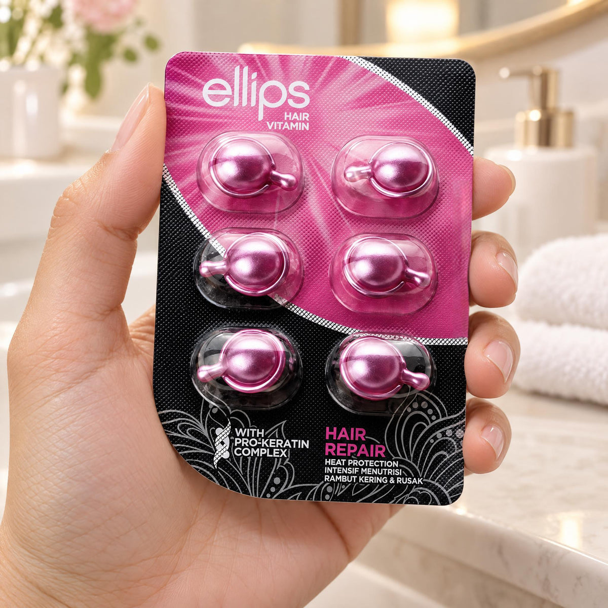 Hand holding the Ellips Hair Repair try size blister of 6 capsules