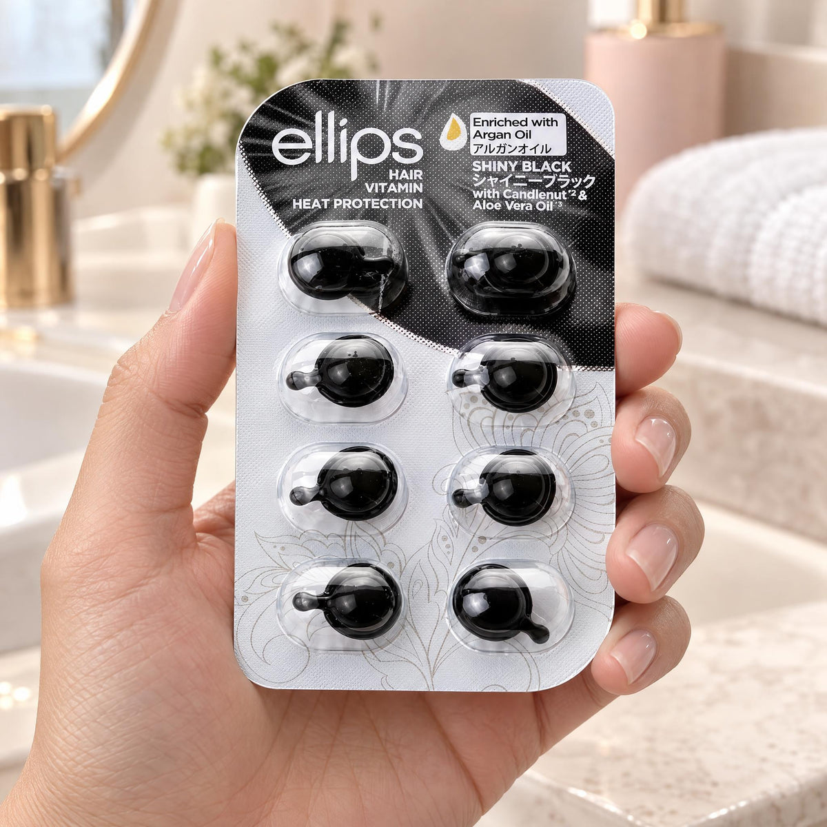 Hand holding the Ellips Shiny Black try size blister of 8 capsules