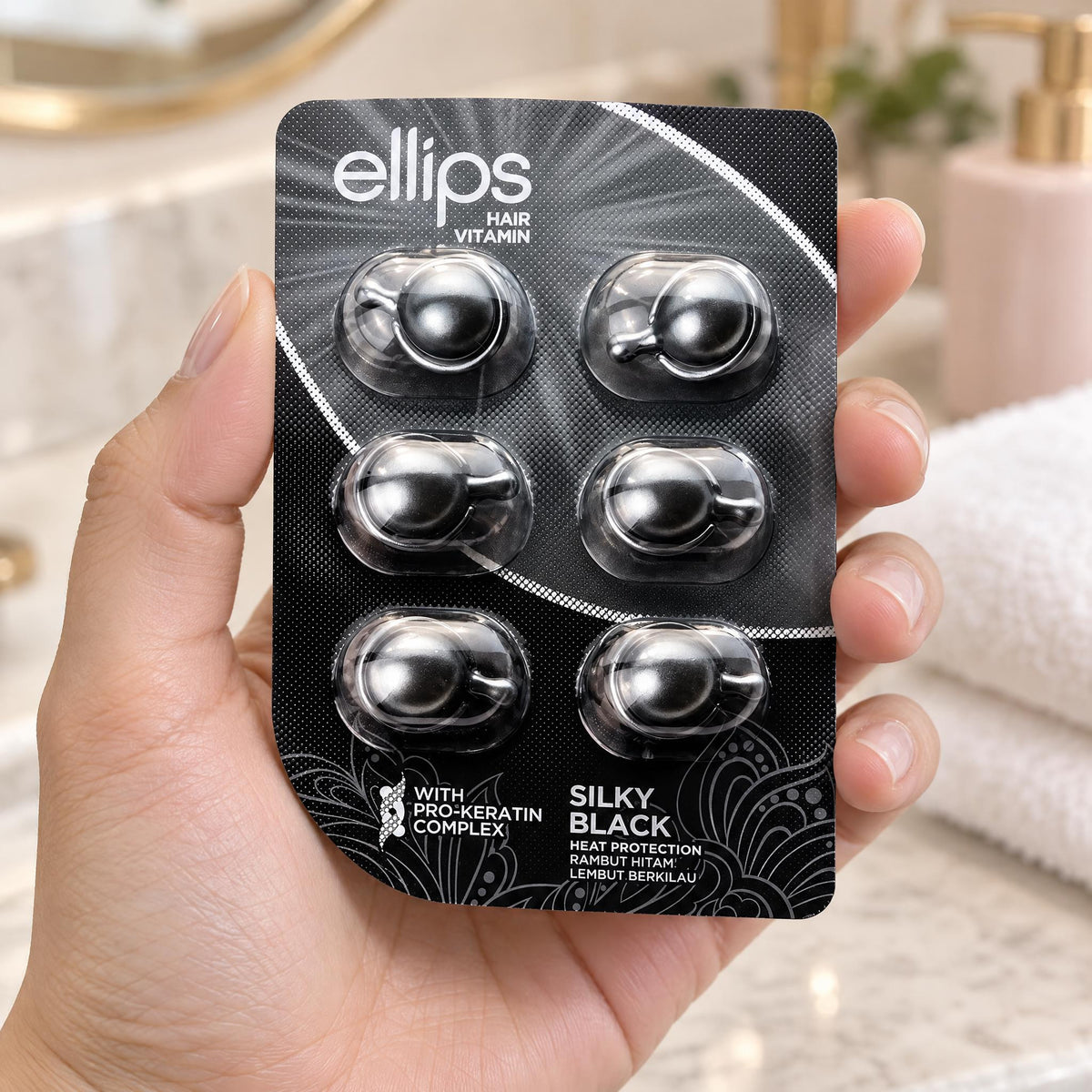 Hand holding the Ellips Silky Black try size blister of 6 capsules