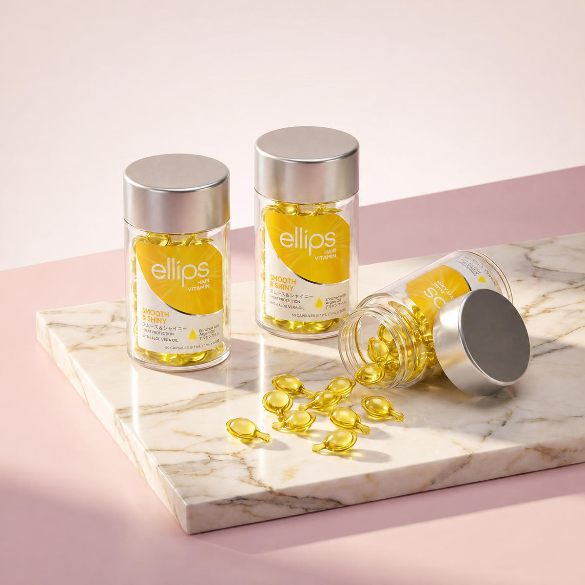 Ellips Smooth & Shiny jars on marble, lemon-yellow capsules spilling from an open jar