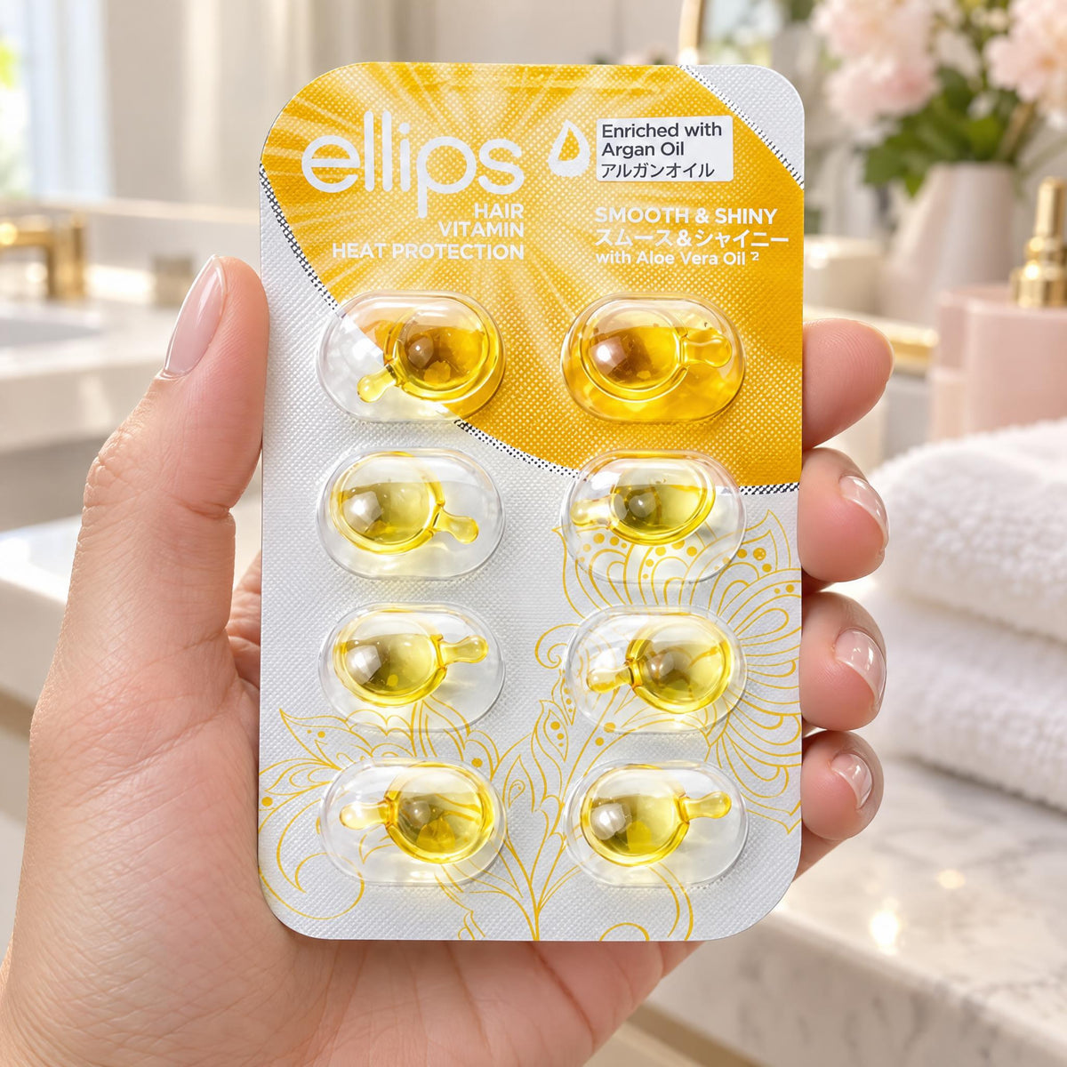Hand holding the Ellips Smooth & Shiny try size blister of 8 capsules